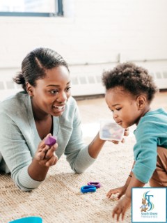 A woman and a toddler playing with small toys together on the floor