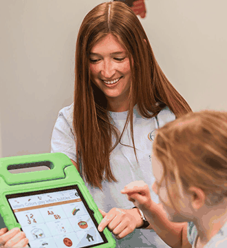 Child Using an Augmentative and Alternative Communication Device with a Therapist in Norwood, MA 